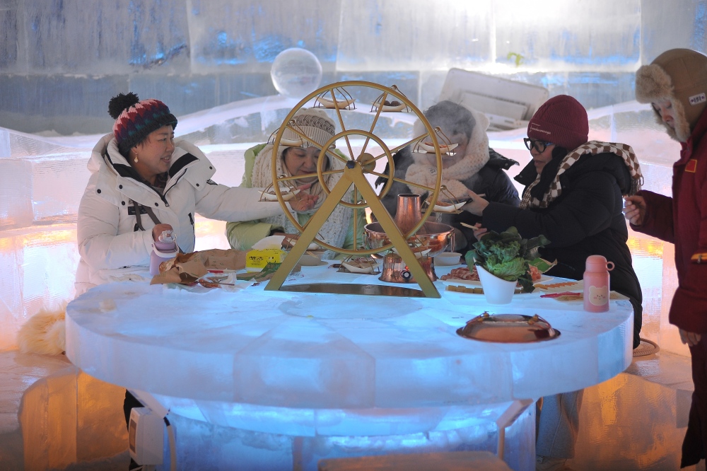 2024年1月10日晚，哈尔滨冰雪大世界内，一些南方游客正在冰屋内品尝着热气腾腾的火锅。